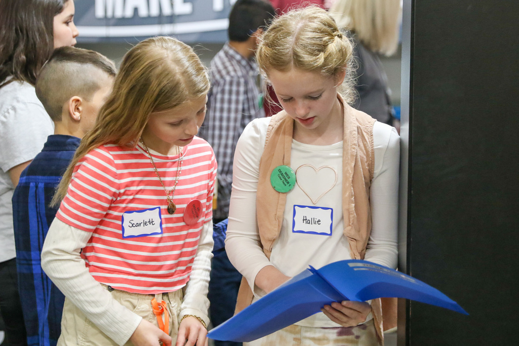 two girls looking at a folder