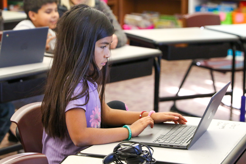 student typing on her computer