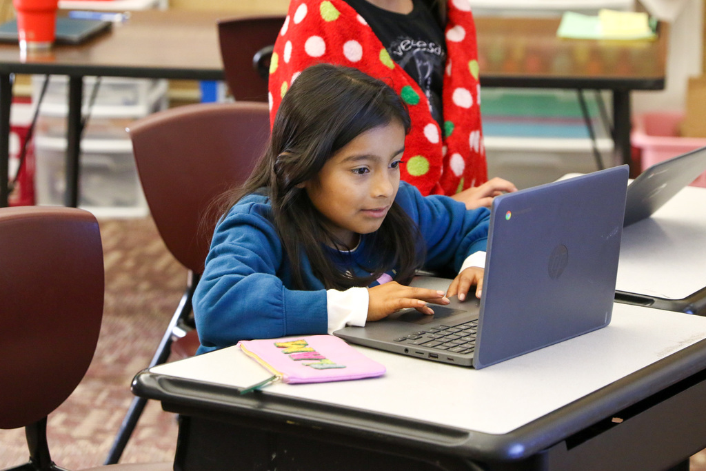 student typing on her laptop
