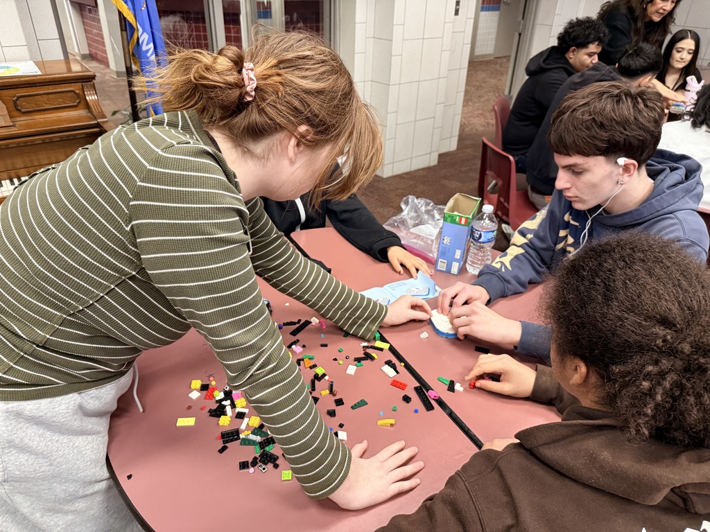 a student reaching for a Lego piece