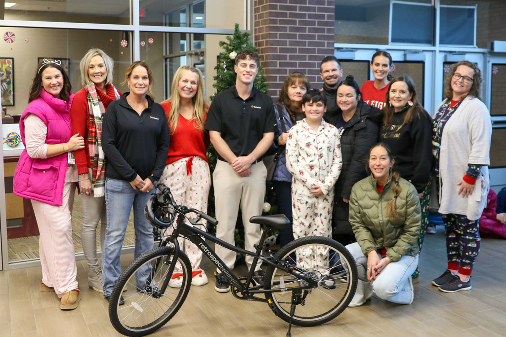 group photo with two bike recipients and their families, swerve members, and principals