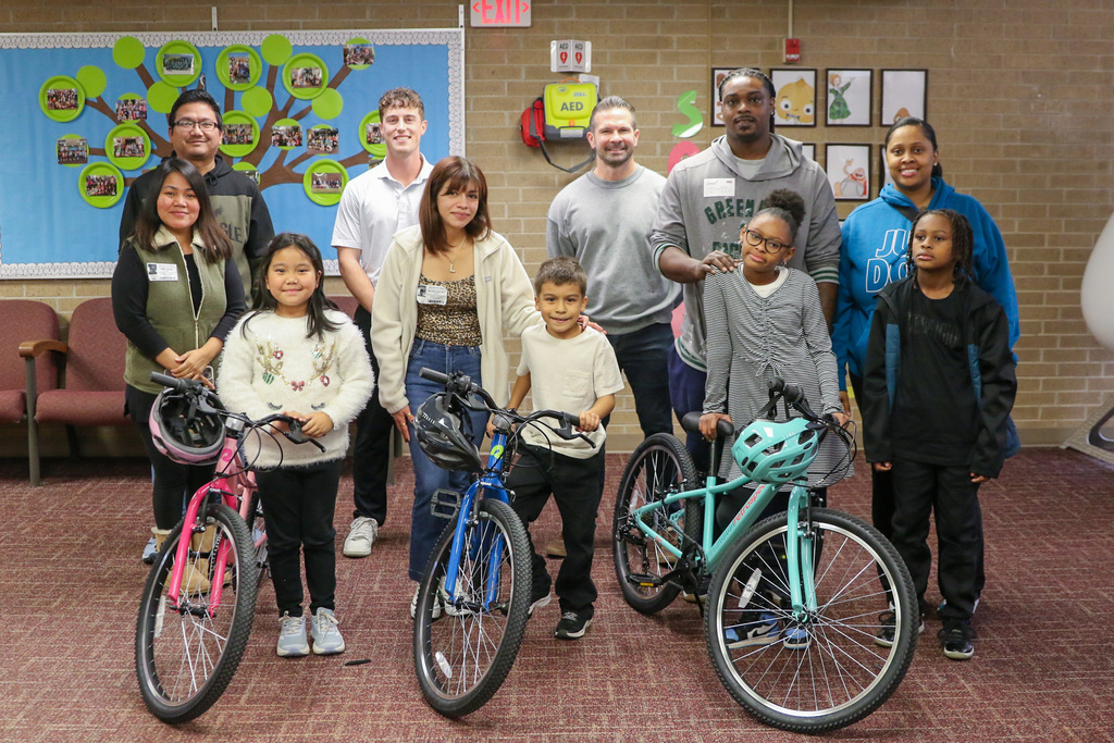 group photo with two bike recipients and their families and swerve members