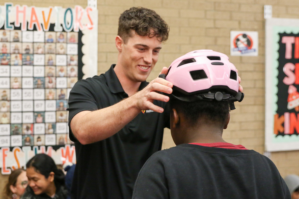 swerve member putting a helmet on a student