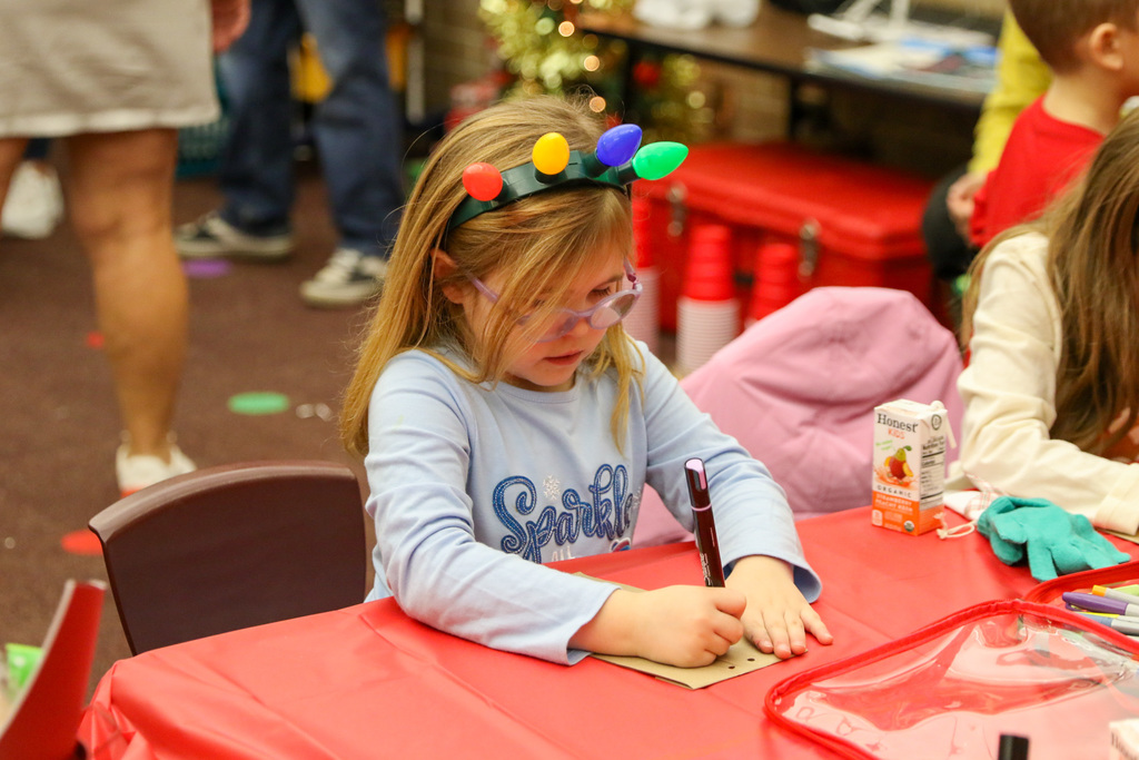 girl decorating a bag for reindeer food
