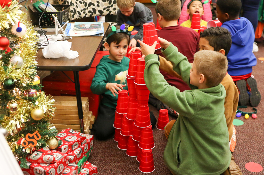 boys are building a tower with red cups