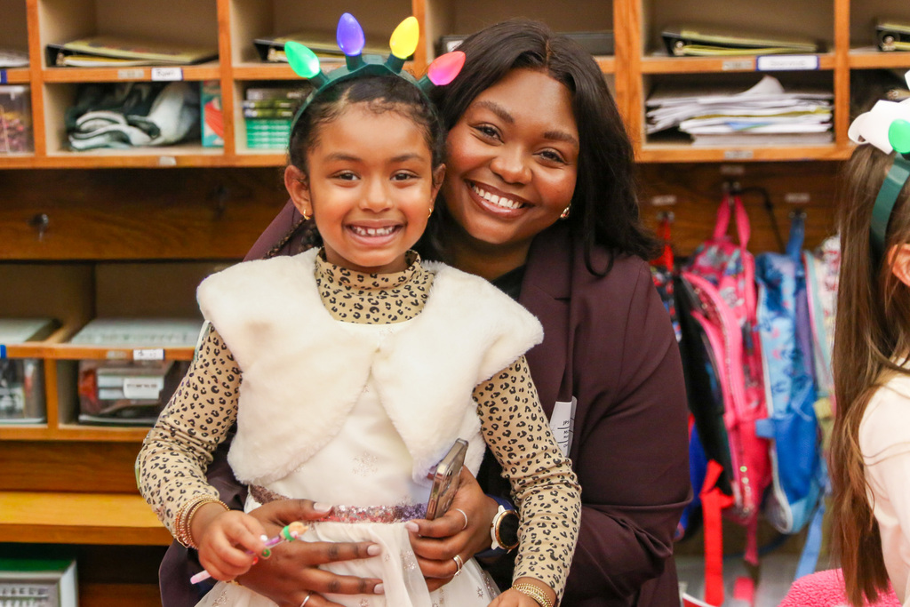 mom and daughter pose for a photo together at a class holiday party