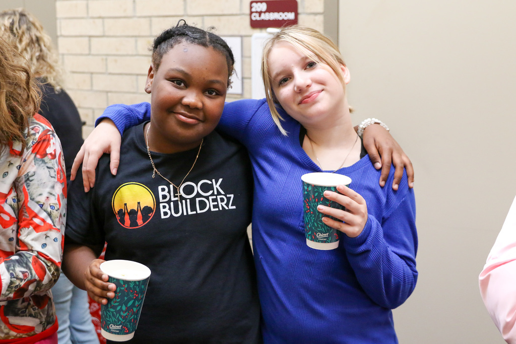 studets holding coco pose for a photo