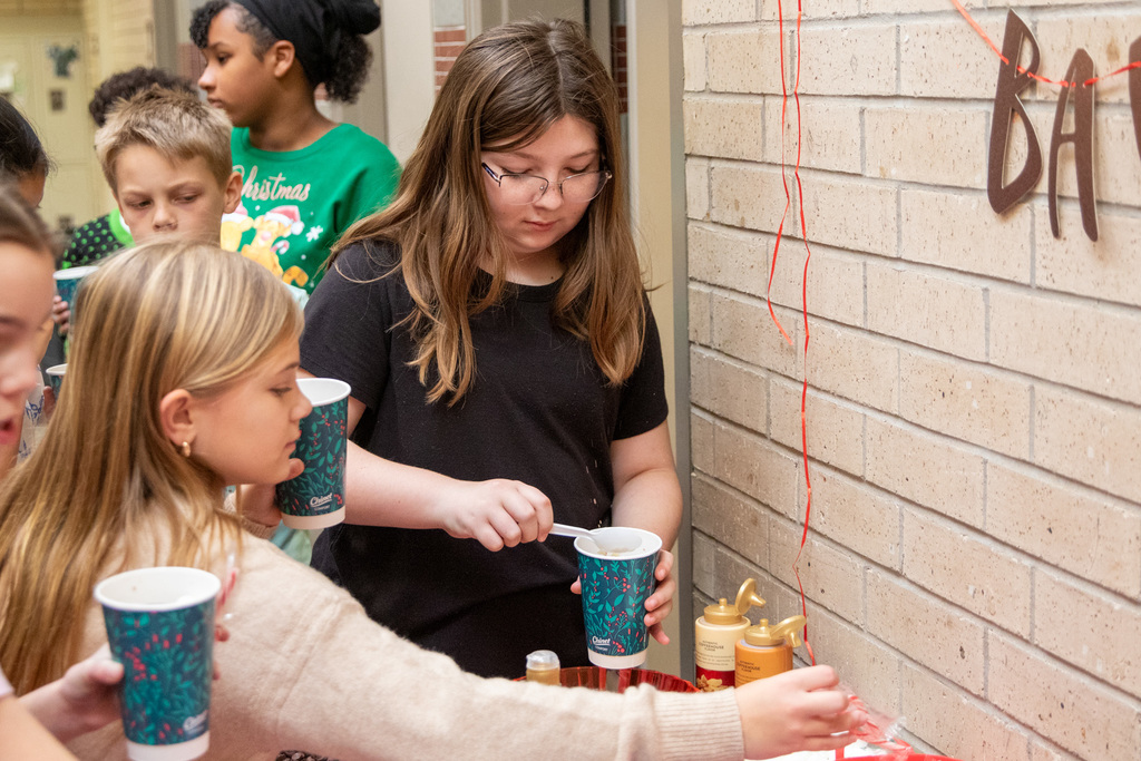 students scooping marshmellows into their hot coco