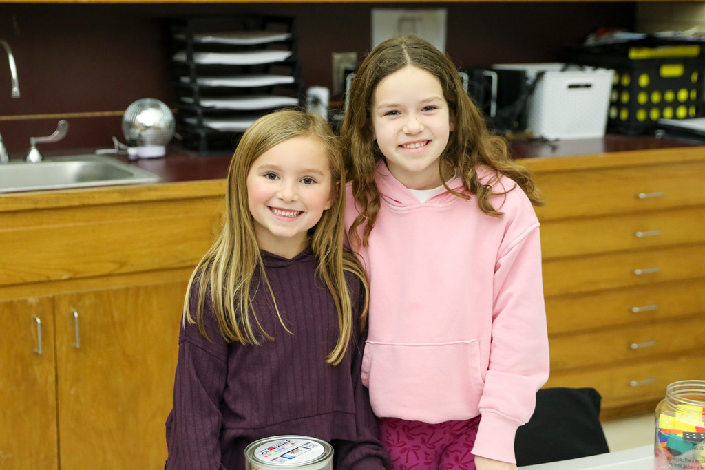 two girls in class smiling for a photo