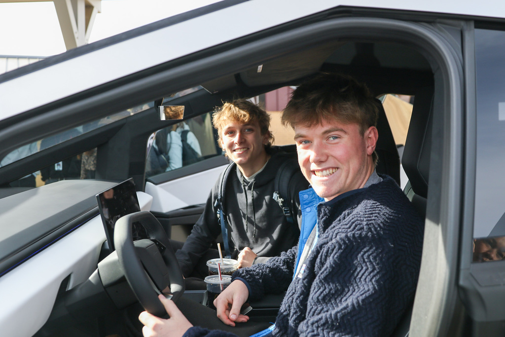 two students sitting in the front of a cyber truck