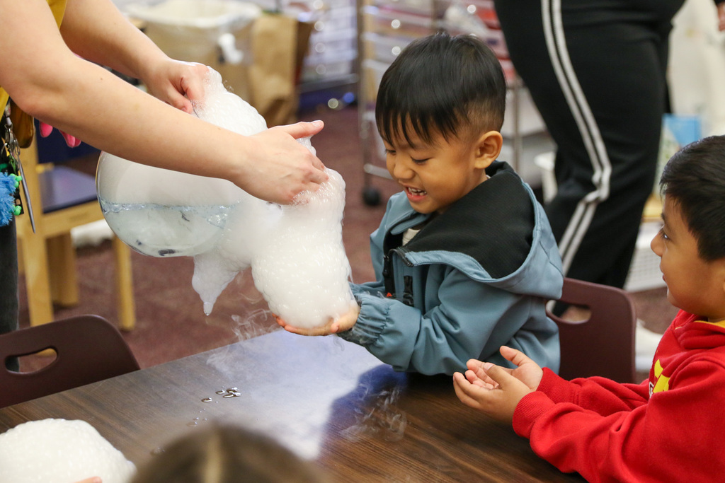 boy getting bubbles put in his handsd