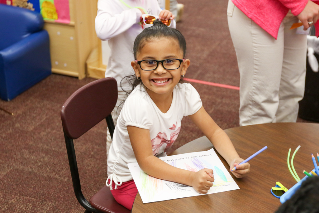 girl smiling while coloring