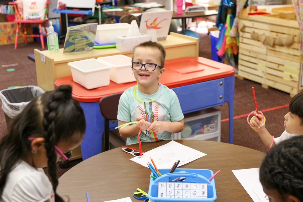 boy smiling playing with glow sticks