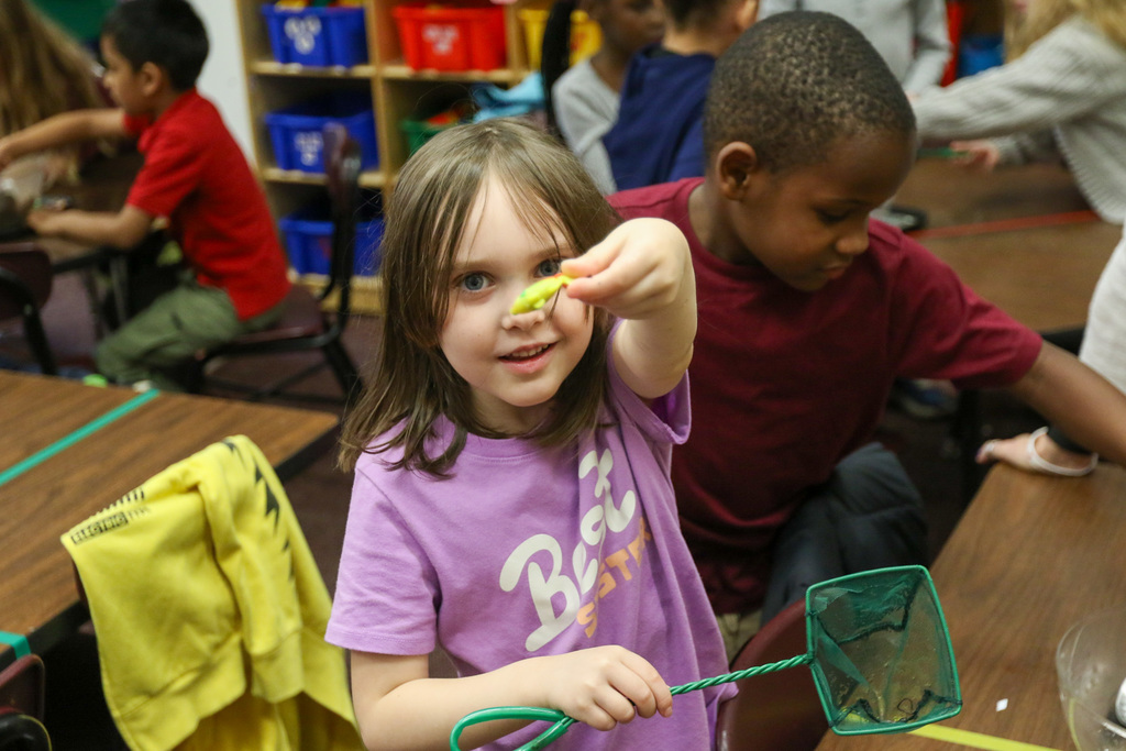 girl holding us a plastic fish she caught
