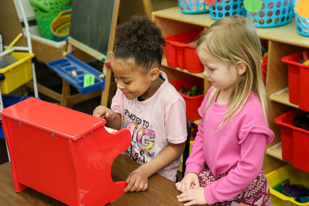 Two girls playing a mini piano