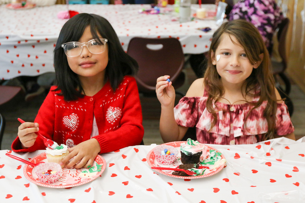 two girls decorating cupcakes