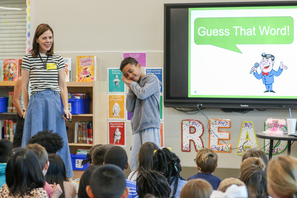 student acting out a word to the students in the crowd playing guess that word