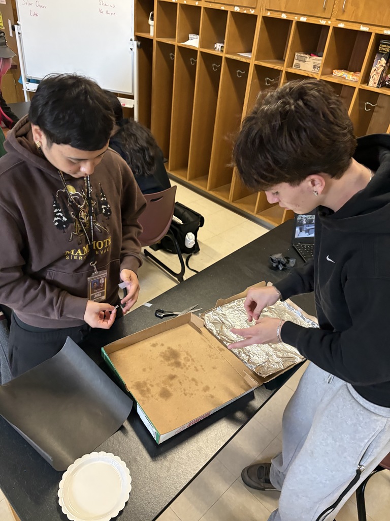 2 students working with foil and cardboard