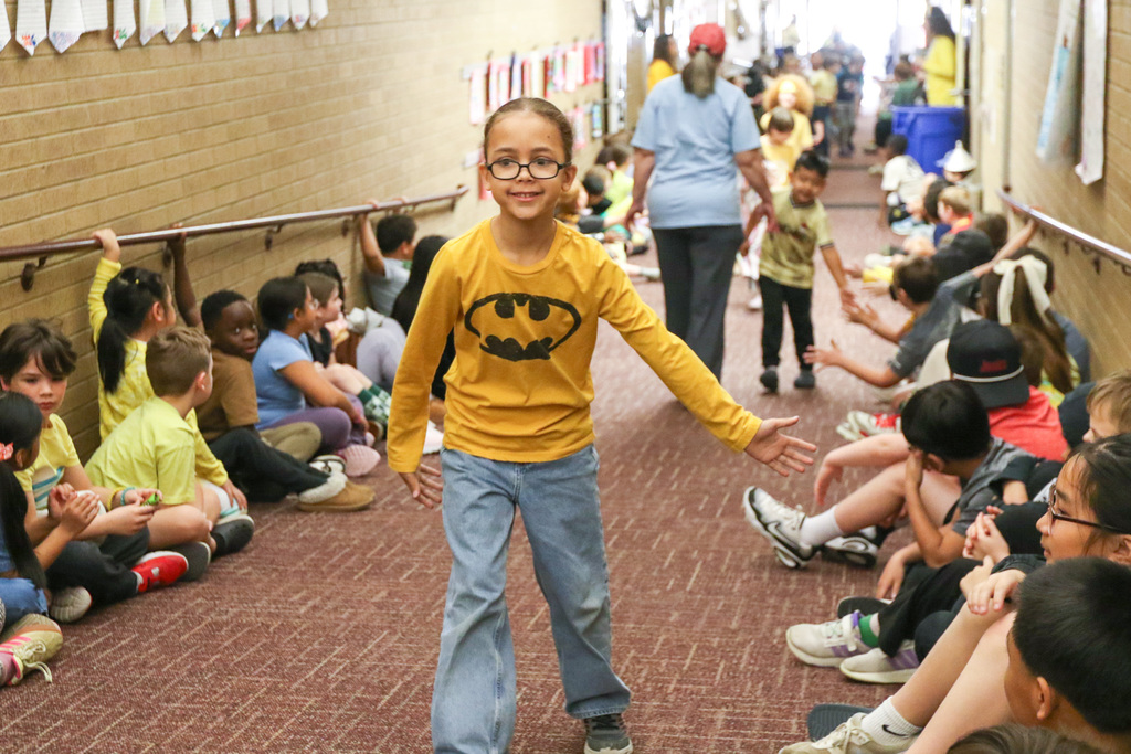 boy in yellow high fiving other students