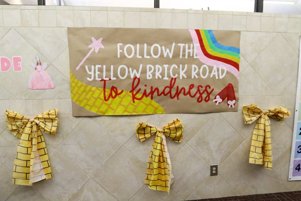 hand made sign that says follow the yellow brick road to kindness