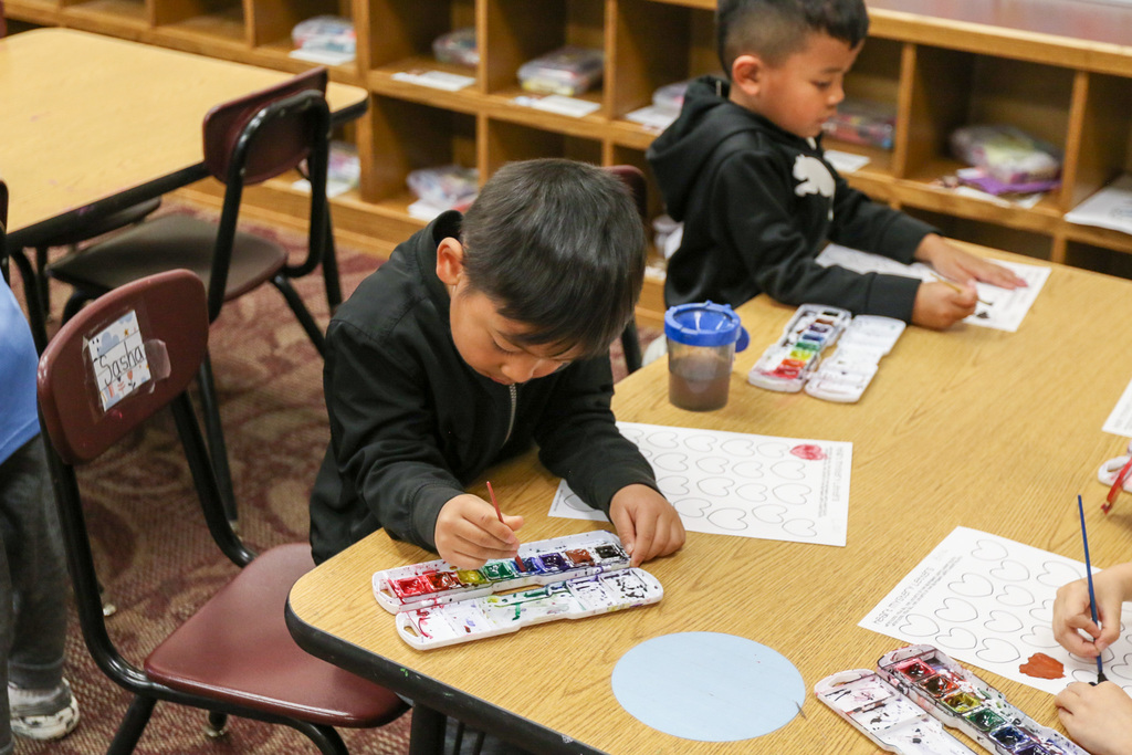 student is painting hearts