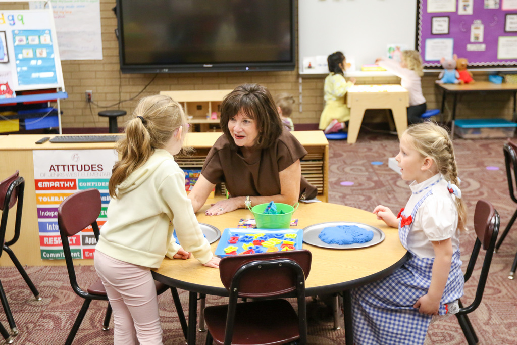 Dr. butterfield at a table with 2 prek students.