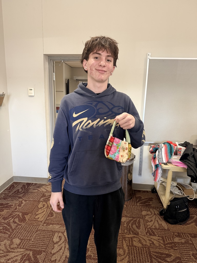 a student holding a small bag he made