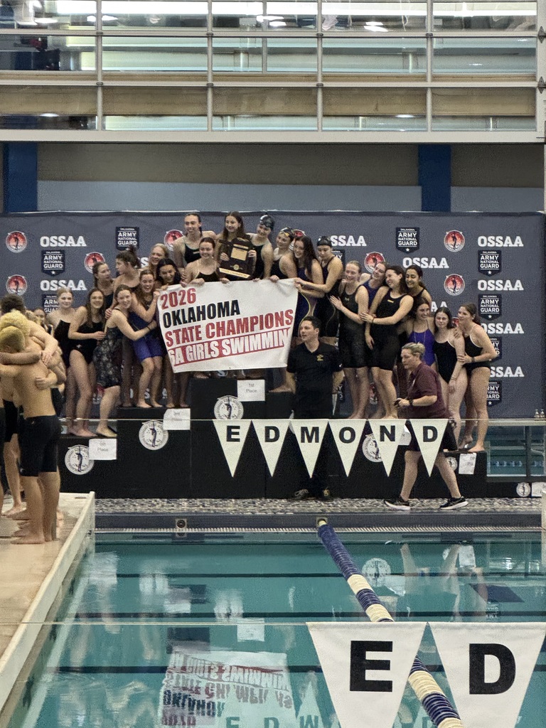 Jenks' girls swimmers on podium holding state championship banner