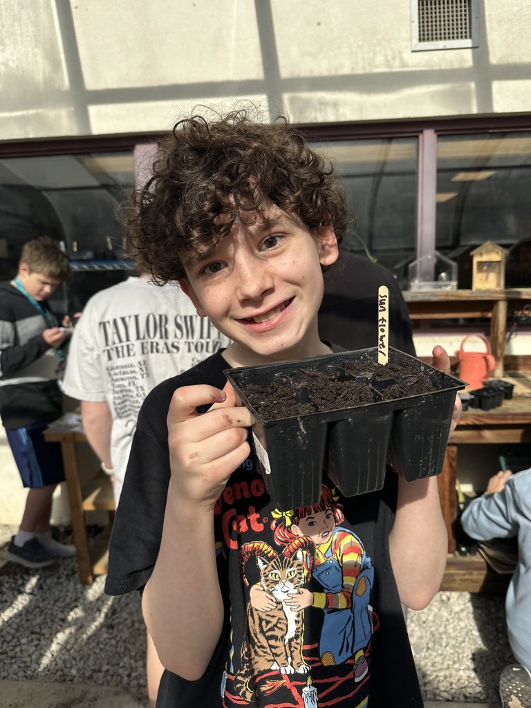 student holding potted seeds