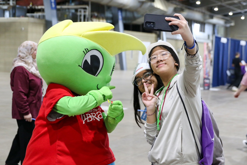 students talking a selfie with the tulsa city-county library mascot