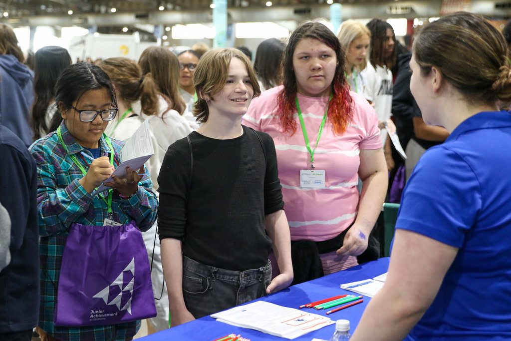 students at a table listening to a professional