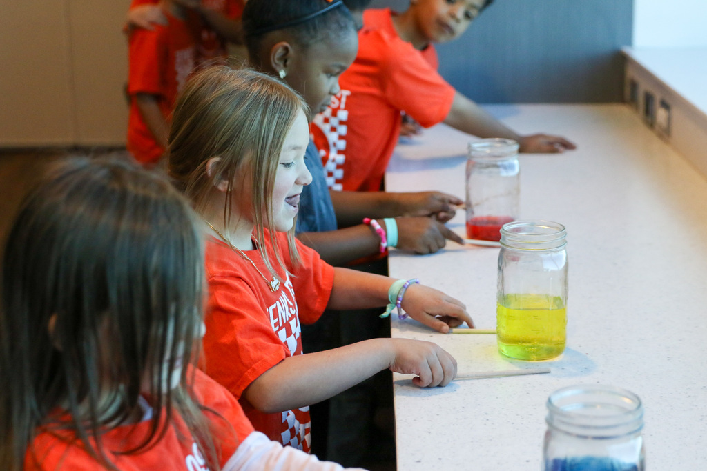 Students use chopsticks to tap on jars filled with water to make music!