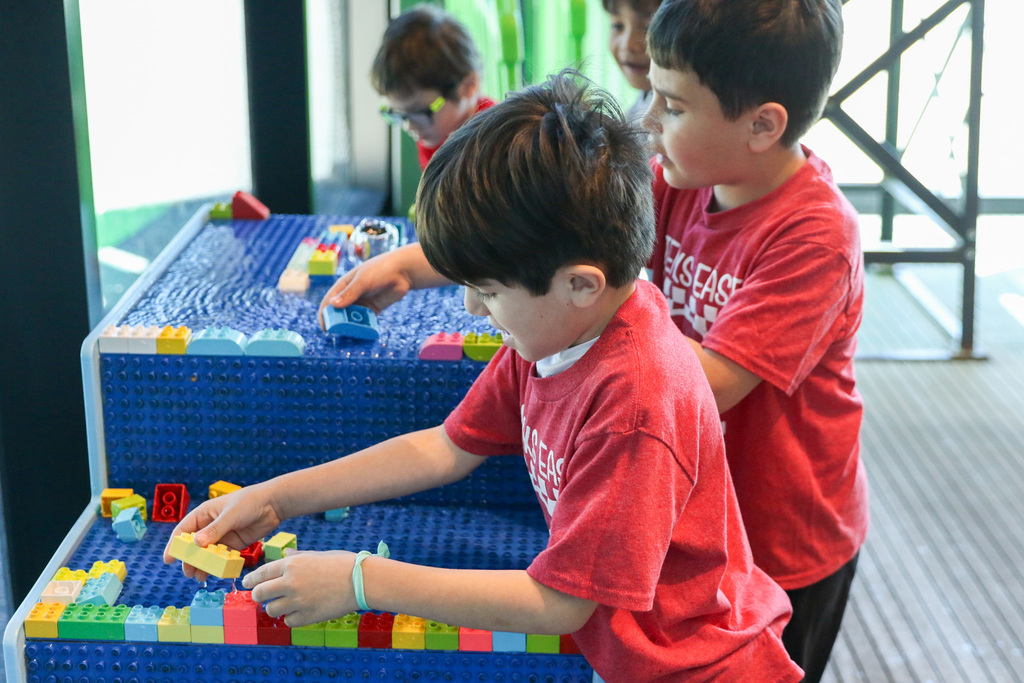 students playing with legos on a water table