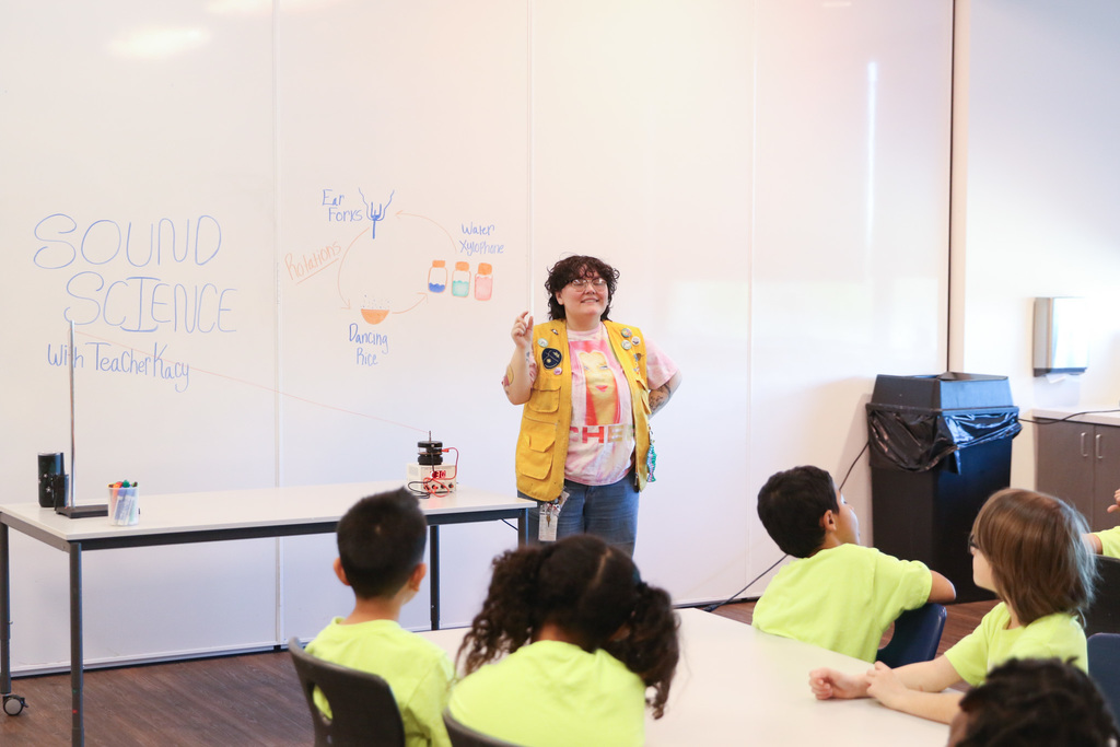 The teacher explaining sound science to a classroom full of studence