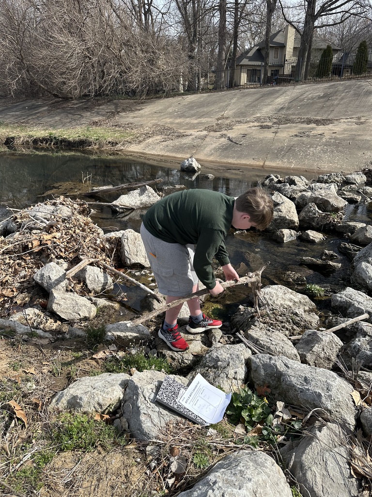 student working in rocks and water