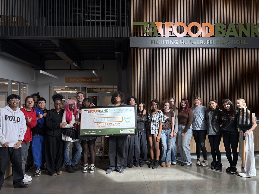 Students lined up in front of the Food Bank sign holding a large poster that says over 6000 lbs packed