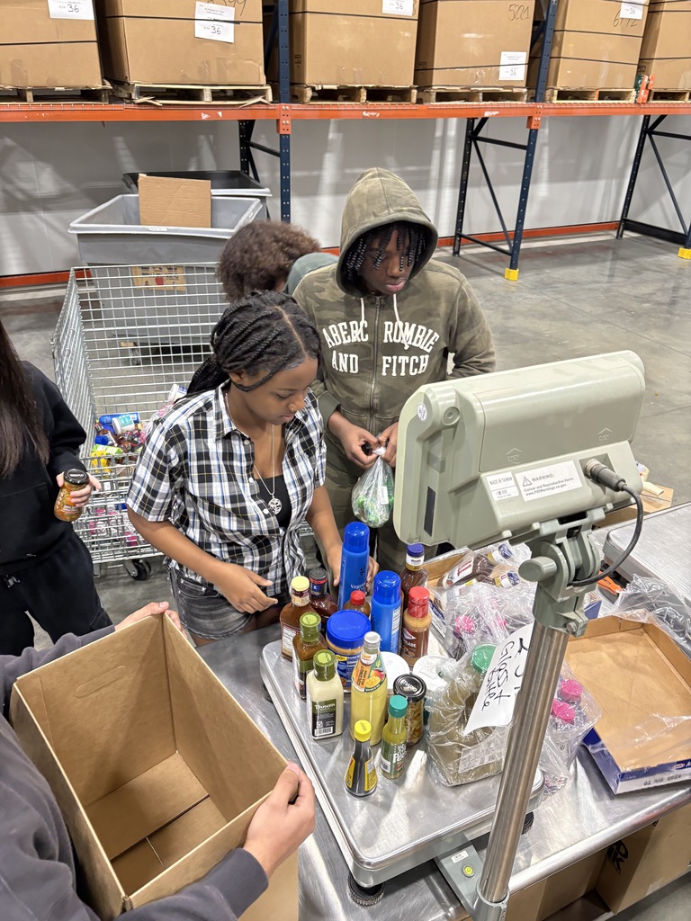 two students organizing items to be placed in a box