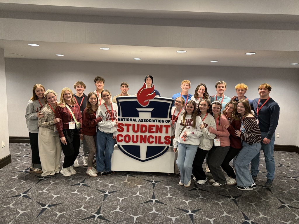 Group of Jenks High School students posing for photo around sign for National Association of Student Councils
