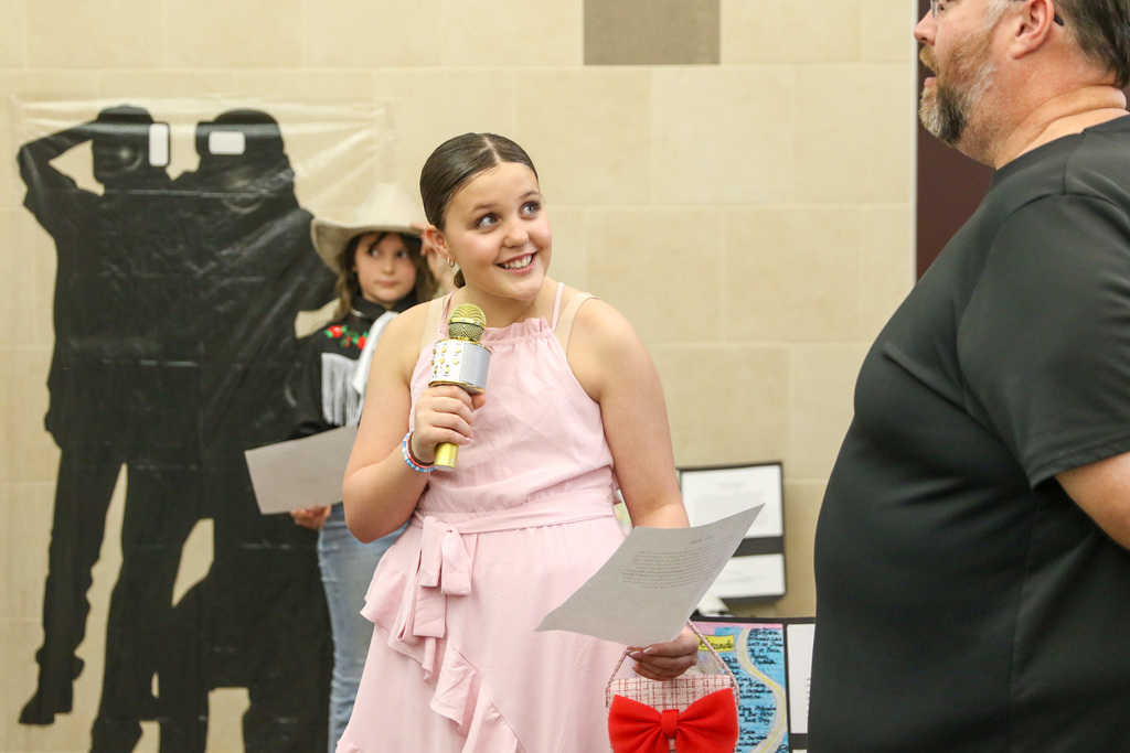 Student dressed up as Ariana Grande presenting their research.