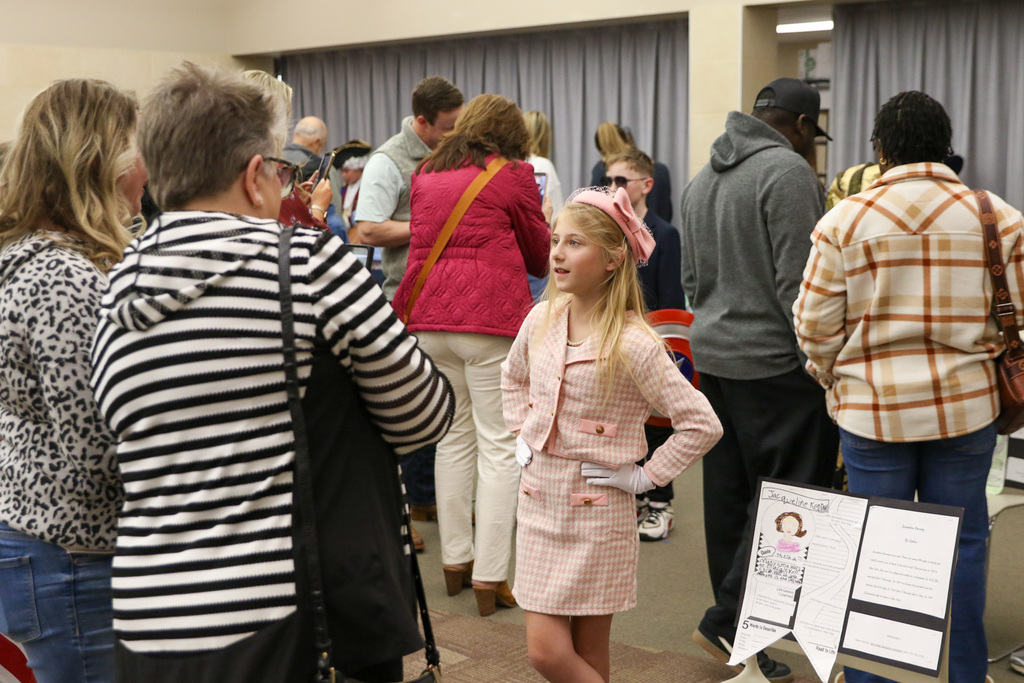 Girl dressed as Jaqueline Kennedy presenting her project.