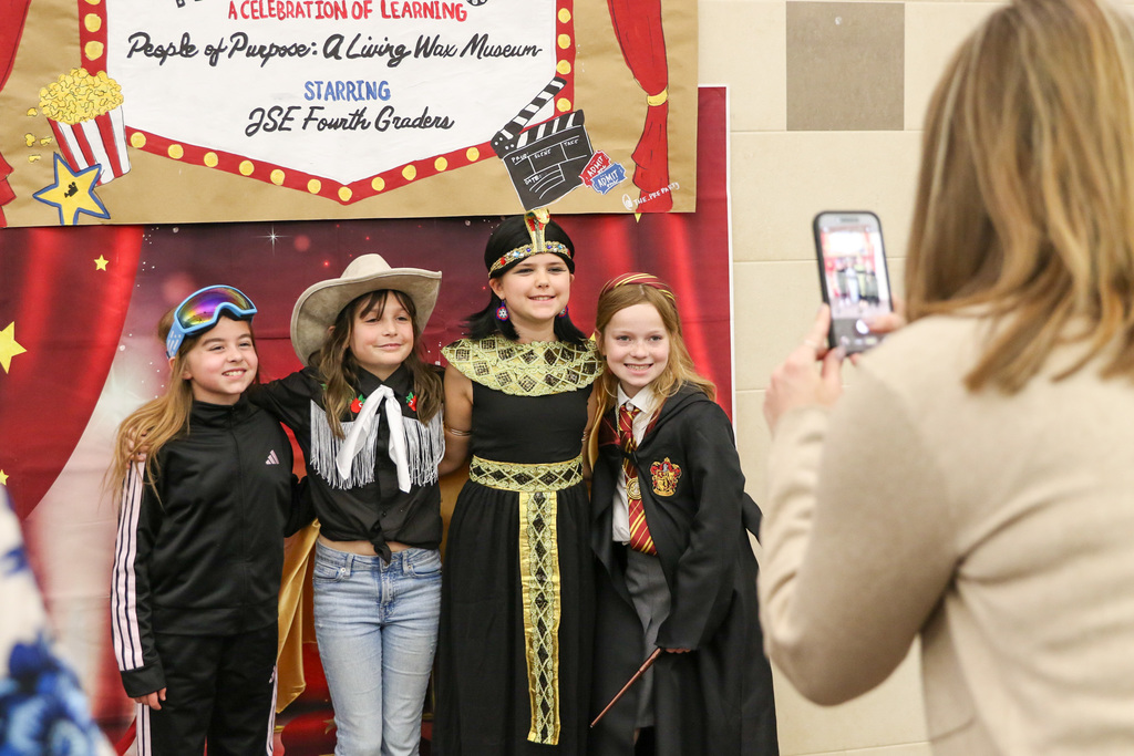 Four girls dressed up posing for a photo together.
