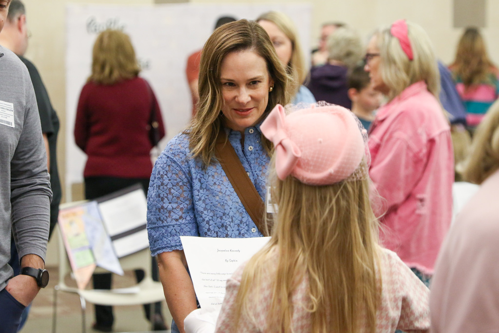 A parent listening to a student present.