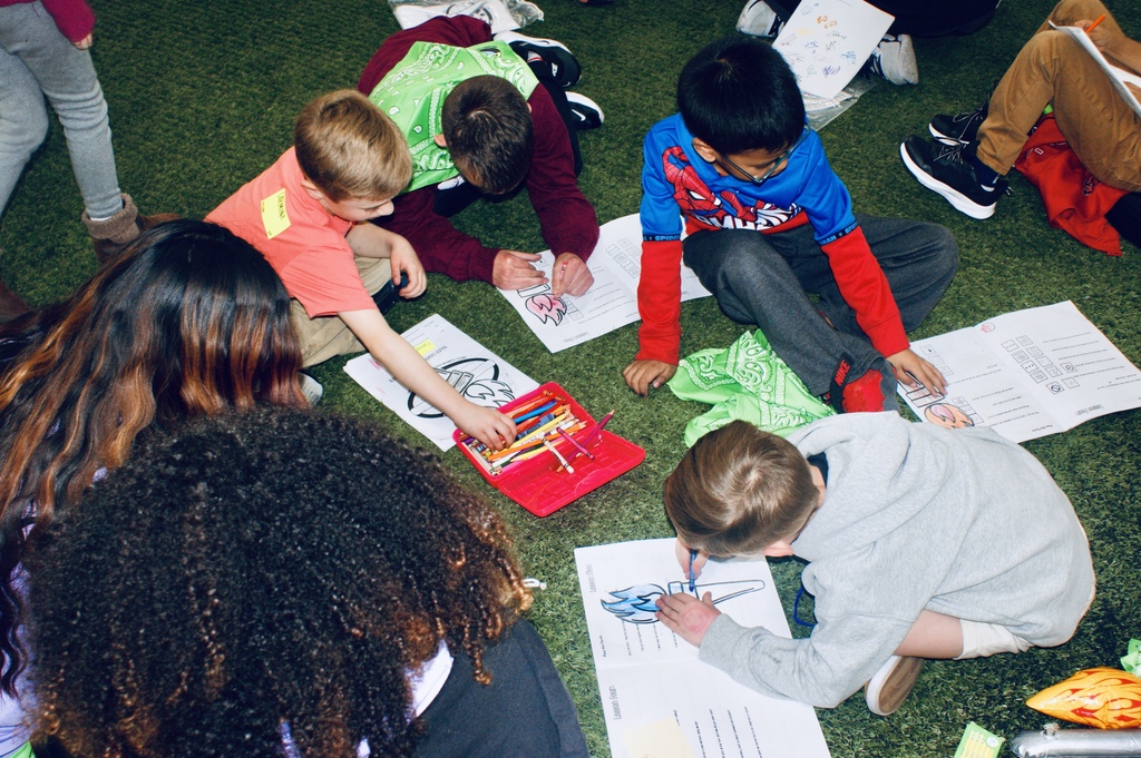 Group of students coloring an Olympic torch.