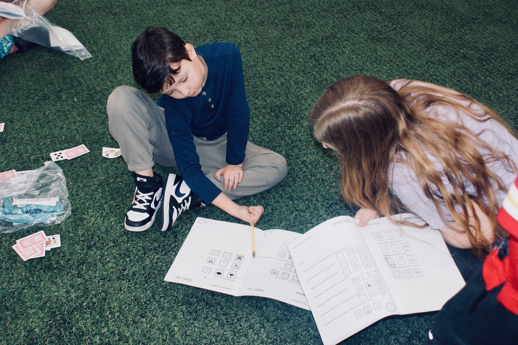 Students completing a card game challenge.