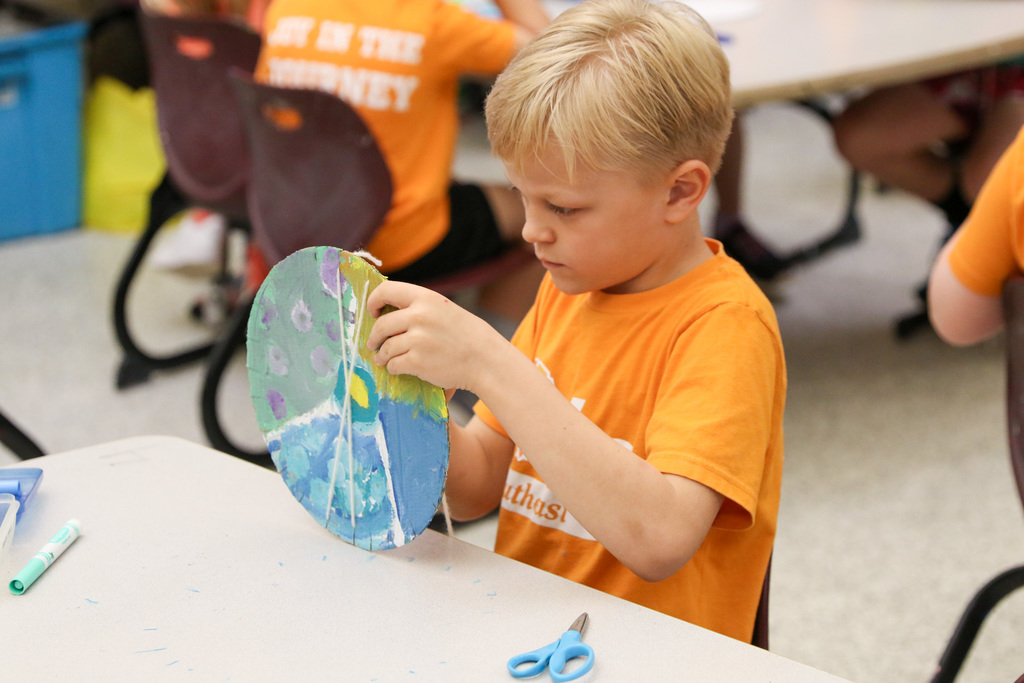 Boy in art class circle weaving.