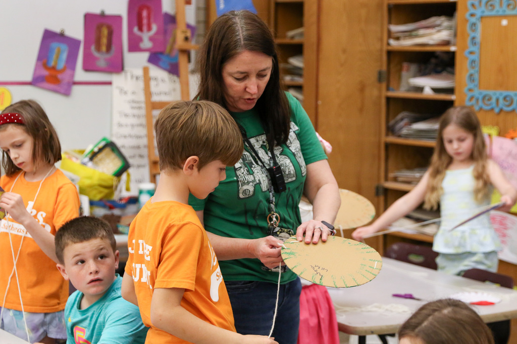 Teacher helping student with his circle weaving.