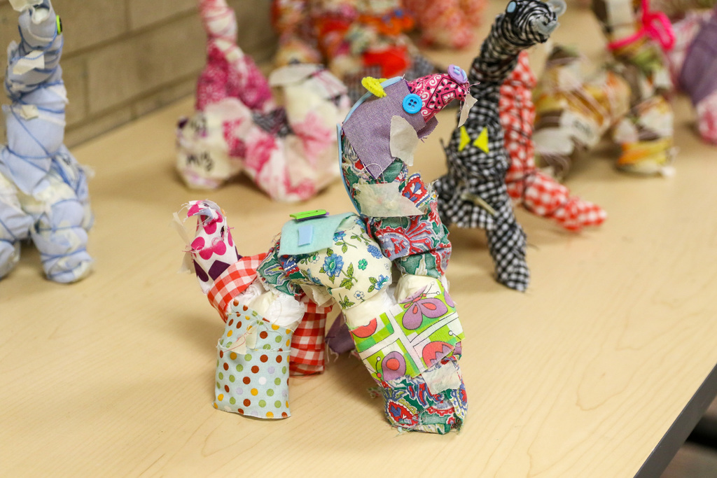 A Scrappy Sculpture made from a metal hanger, plastic bags, and scrap buttons, yarn, and fabric.