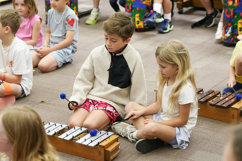 Two students paired together playing the xylophone.