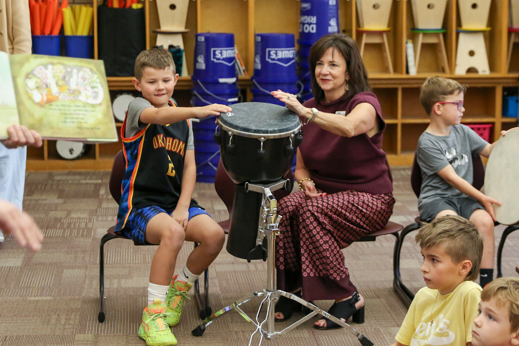 Dr. Butterfield playing a drum alongside a student.