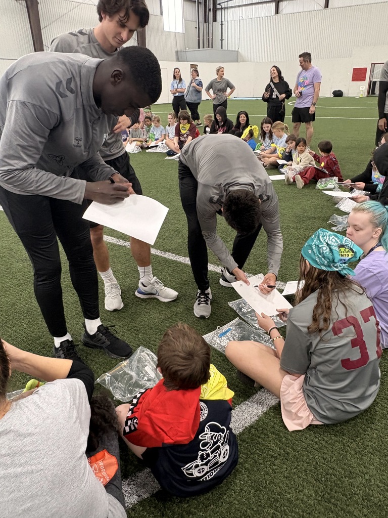 FC Tulsa players signing students' notebooks.